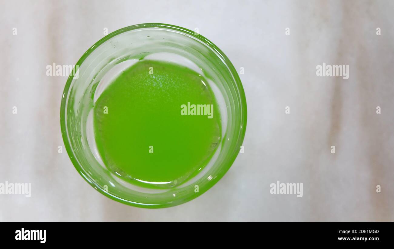 Vista dall'alto di un bicchiere pieno di vivace bevanda analcolica verde. Foto Stock