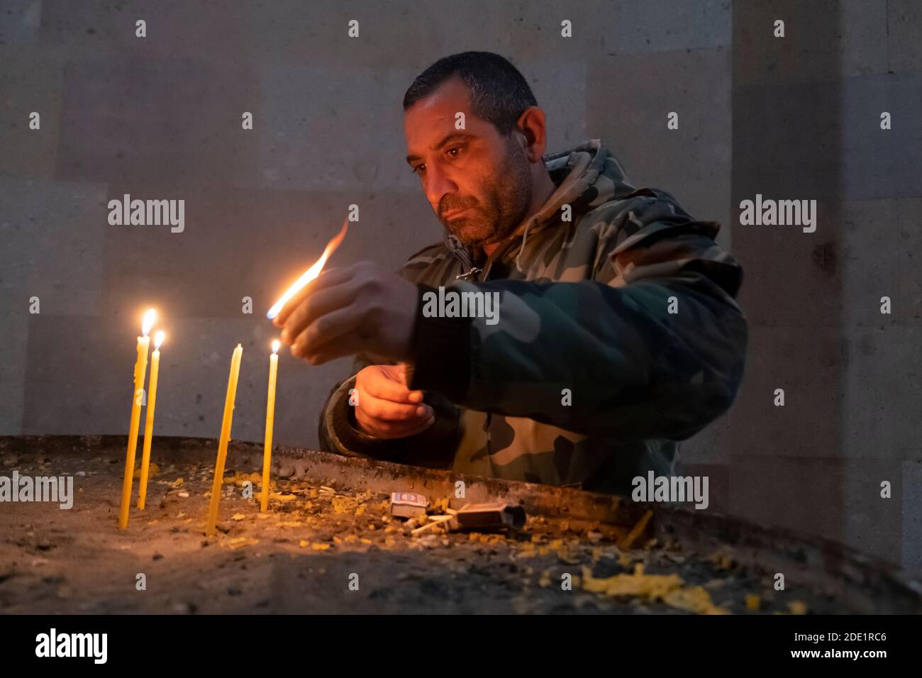 STEPANAKERT, NAGORNO KARABAKH - NOVEMBRE 05: Soldato dell'Armata di Difesa accende le candele all'interno della Cattedrale della Santa Madre di Dio, Conosciuta anche come Surb Astvatsamor Hovanu Cattedrale in durante un conflitto militare tra le forze armene e azerbaigiane in Stepanakert la capitale de facto della Repubblica autoproclamata di Artsakh o Nagorno-Karabakh de jure parte della Repubblica di Azerbaigian il 04 novembre 2020. I combattimenti tra l'Armenia e l'Azerbaigian sul Nagorno-Karabakh, conosciuto anche come la Repubblica Artsakh, rieruttarono alla fine di settembre in una guerra di sei settimane che lasciò migliaia di morti. Foto Stock