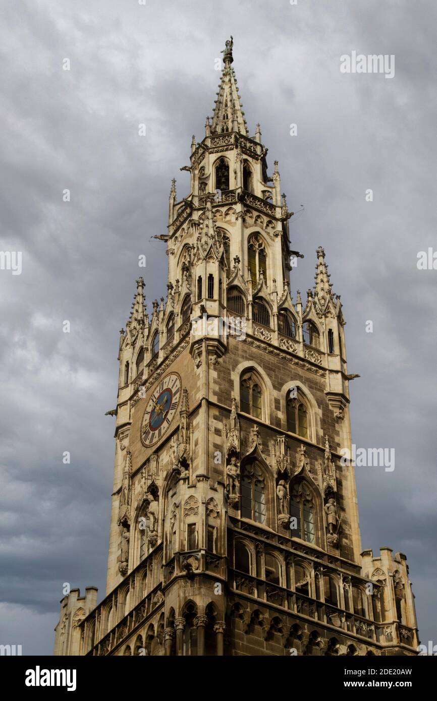 Vista ad angolo basso del particolare del campanile del nuovo Municipio neo-gotico a Marienplatz, Monaco, Baviera, Germania, posto contro un cielo nuvoloso Foto Stock
