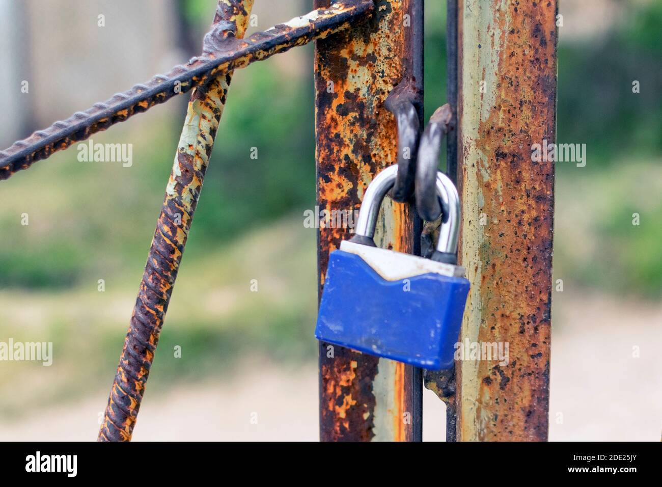 Un lucchetto pende su un cancello arrugginito. Concetto di sicurezza, protezione dei dati, password e hacking degli account. Sollevare le chiavi della serratura. Foto Stock