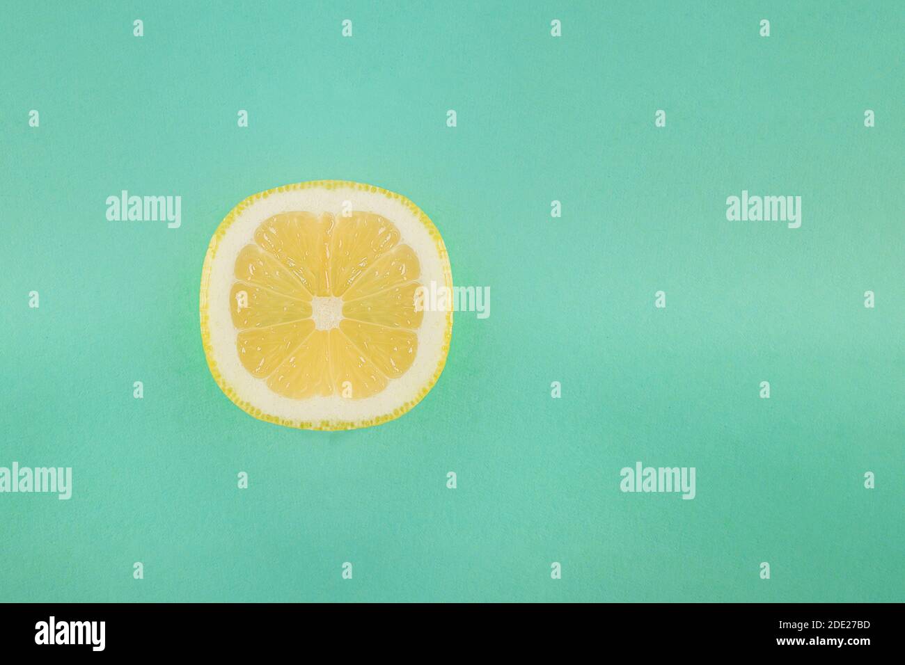 Vista dall'alto di mezzo limone tagliato a metà su sfondo color pastello turchese e spazio per inserire un testo. Cibo sano. Foto Stock