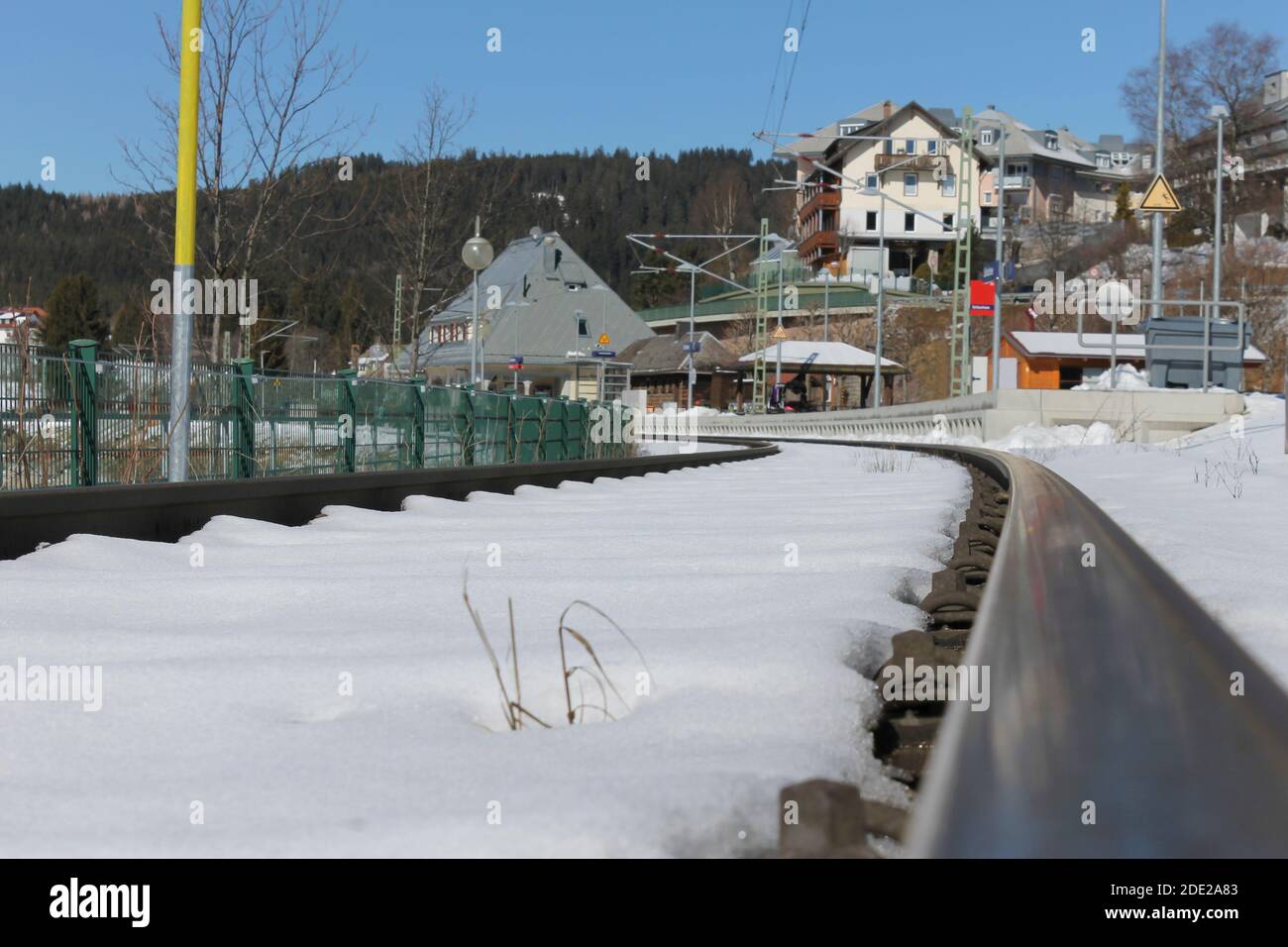 Binari ferroviari con neve.Schluchsee stazione ferroviaria in Germania sullo sfondo, nel paesaggio invernale Foto Stock