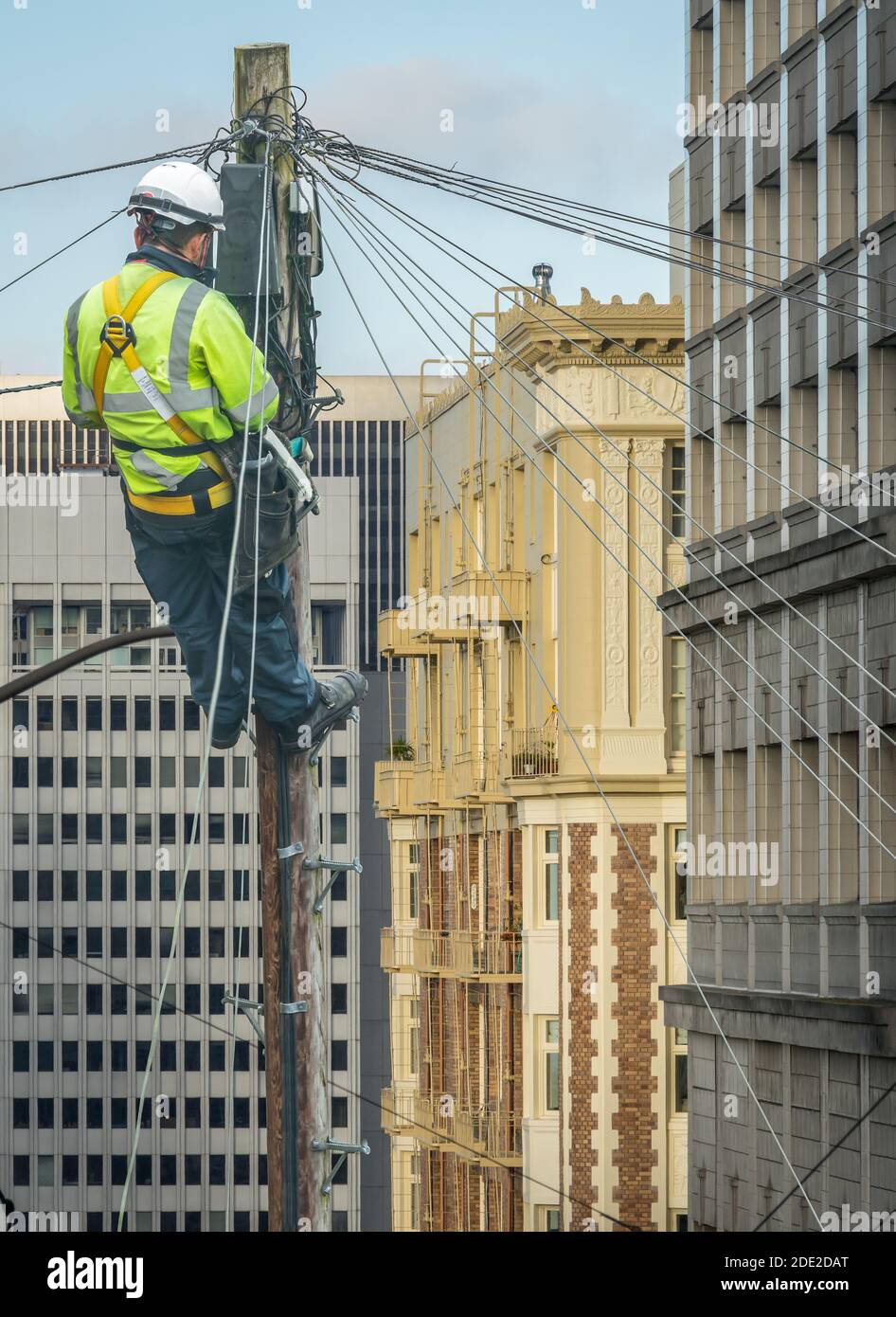Lineman (o Lineworker o Engineer) in una città (San Francisco) Fissaggio DI una linea telefonica Foto Stock
