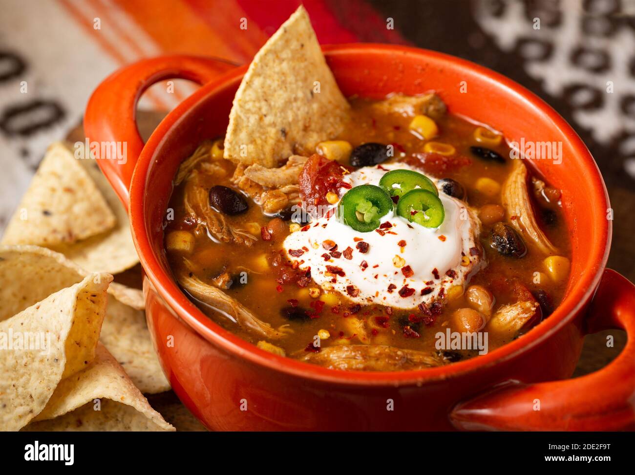 Primo piano di una ciotola di zuppa di pollo taco con panna acida e peperoncini con patatine di tortilla Foto Stock