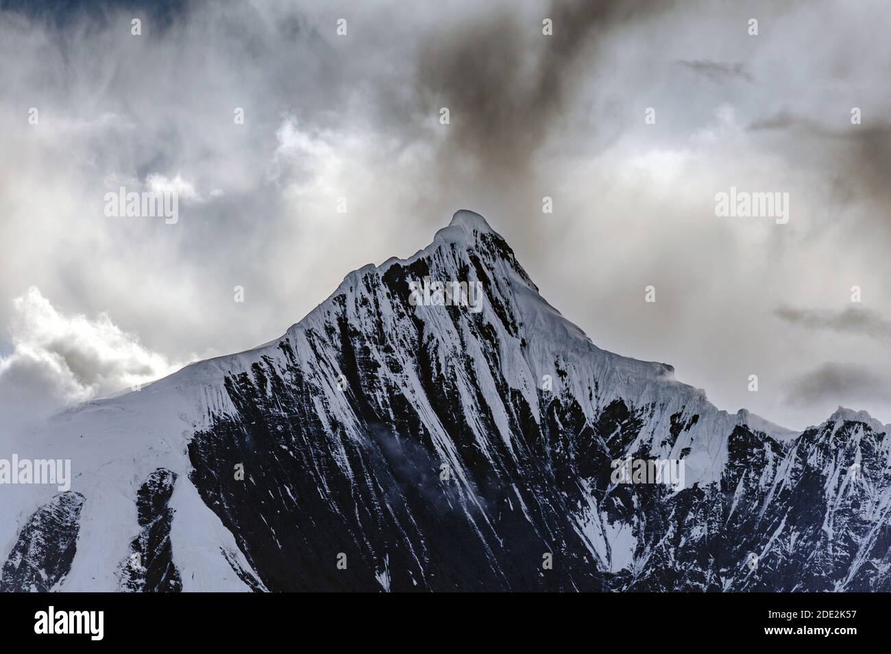 Picco innevato di Kawagarbo o Kawa Karpo (anche trascritto come Kawadgarbo, Khawakarpo, Moirig Kawagarbo, Kha-Kar-po o Kawagebo Peak) sotto una nuvolosa Foto Stock