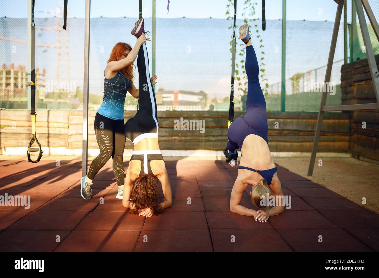Le donne che fanno l'esercizio di equilibrio con l'istruttore Foto Stock