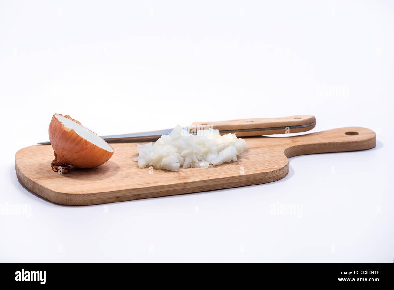 Tritato e mezza cipolla su un tagliere di legno isolato su sfondo bianco Foto Stock