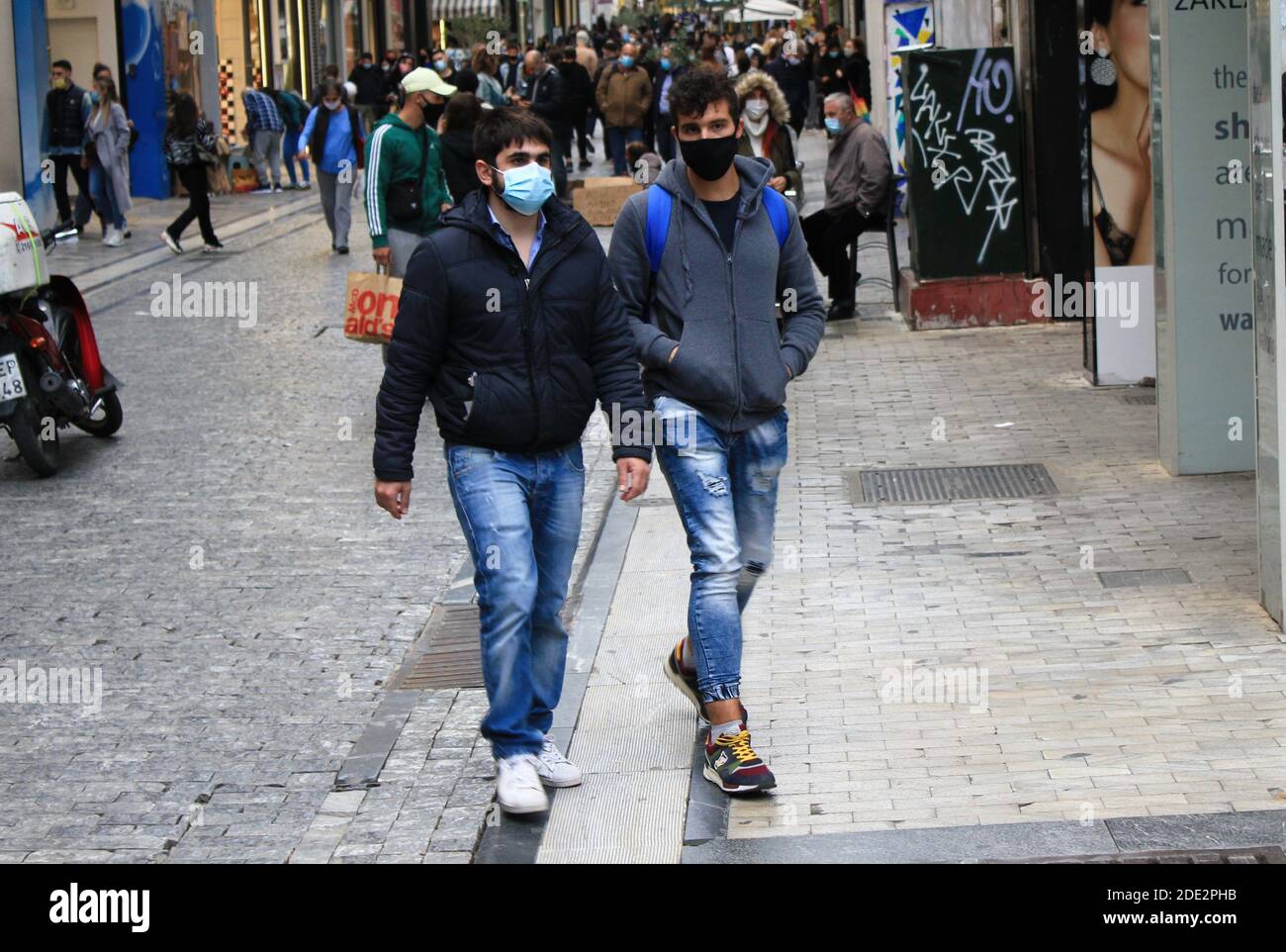 Persone che camminano in via Ermou nel centro di Atene dopo l'annuncio di un secondo blocco in Grecia dal 7 al 30 novembre 2020, dovuto t Foto Stock