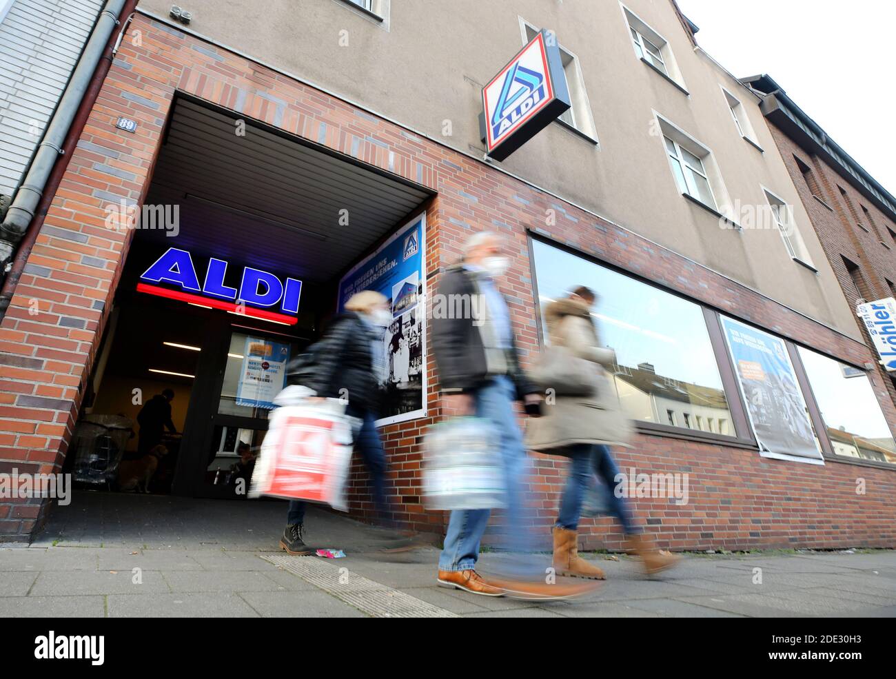 Essen, Germania. 28 Nov 2020. Gli ultimi clienti del più antico negozio Aldi portano a casa la loro shopping. Dopo 101 anni di commercio alimentare nel luogo di nascita dei fondatori di Aldi Karl e Theo Albrecht, il gruppo di società ha chiuso la propria filiale nella sede centrale di Essen. Il negozio in Huestraße 89, che ora è molto troppo piccolo, chiuso le sue porte per il bene alle 16 pm il 28.11.2020. Credit: Roland Weihrauch/dpa/Alamy Live News Foto Stock