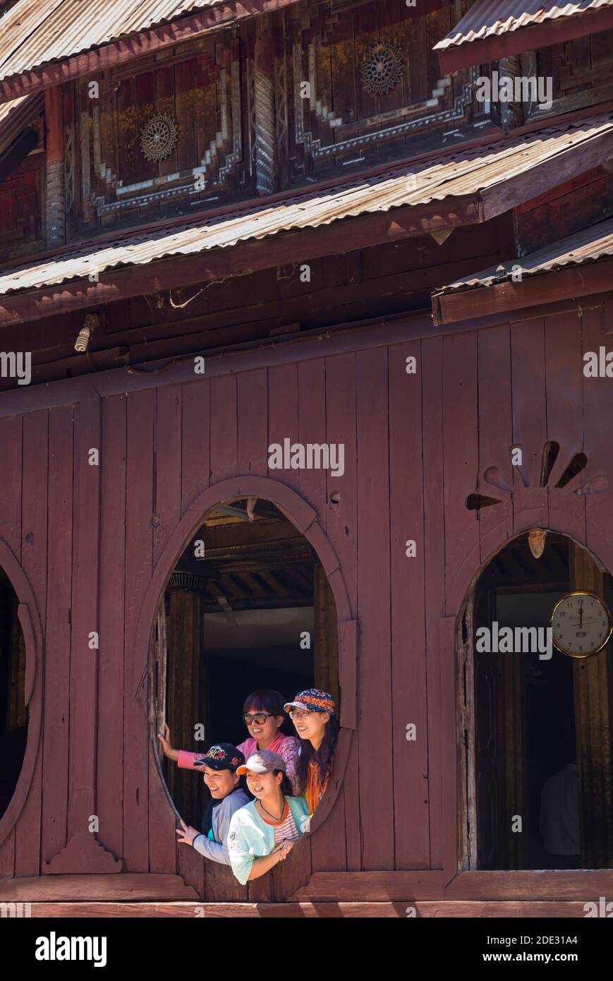 I turisti che posano per una foto a finestre ovali di Shwe Yan Pyay legno teak monastero Shwe Yaunghwe Monastero, Nyaungshwe, Lago Inle, Myanmar (Birmania), Asia Foto Stock