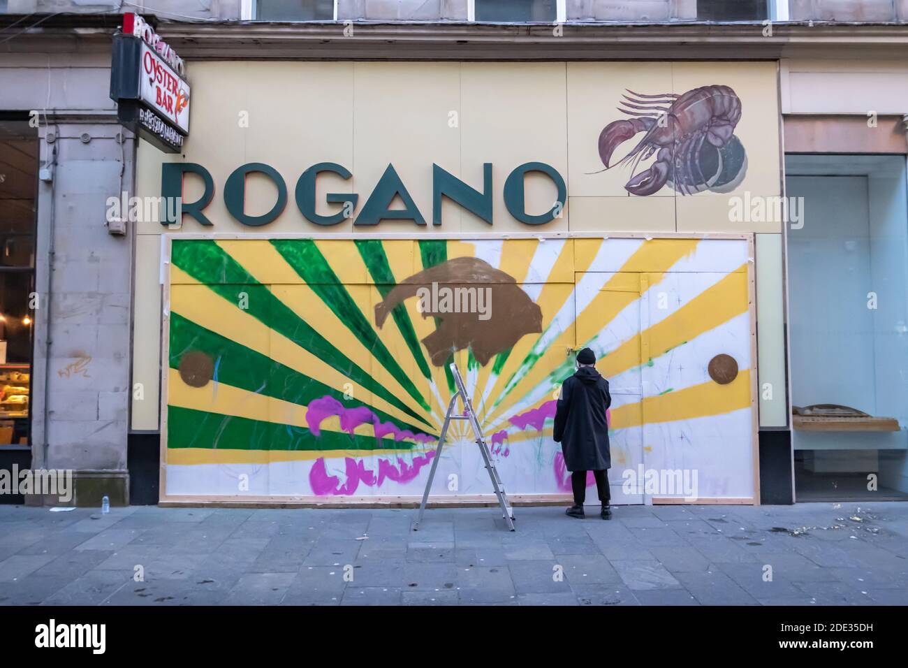 Glasgow, Scozia, Regno Unito. 28 Novembre 2020. L'illustratore e designer Calum Lockerbie di Glasgow lavora su un nuovo murale all'esterno del famoso ristorante Rogano. Credito: SKULLY/Alamy Live News Foto Stock