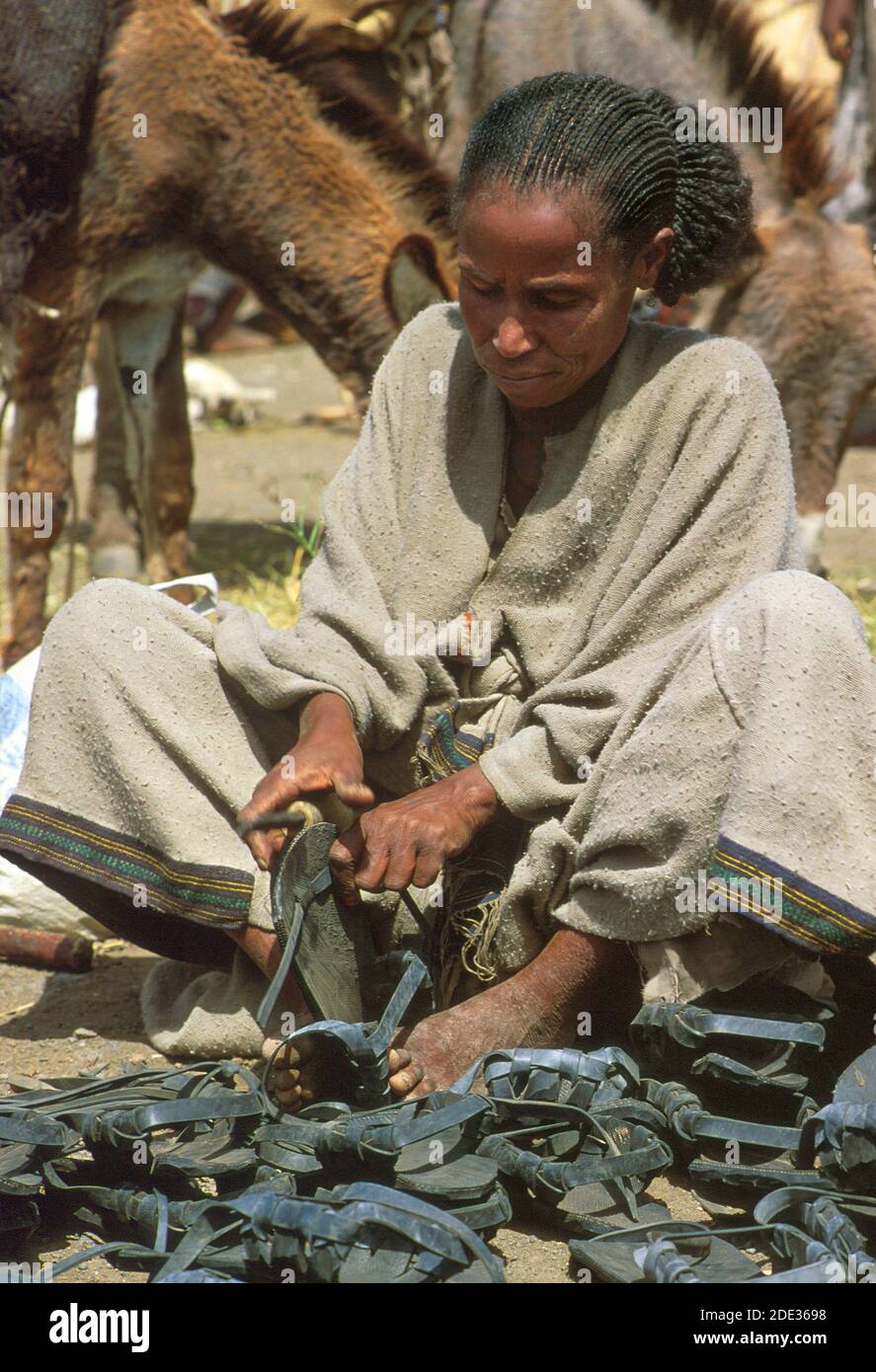 Una donna che fa sandali con pneumatici in gomma riciclata. Mekoni, Tigray, Etiopia Foto Stock