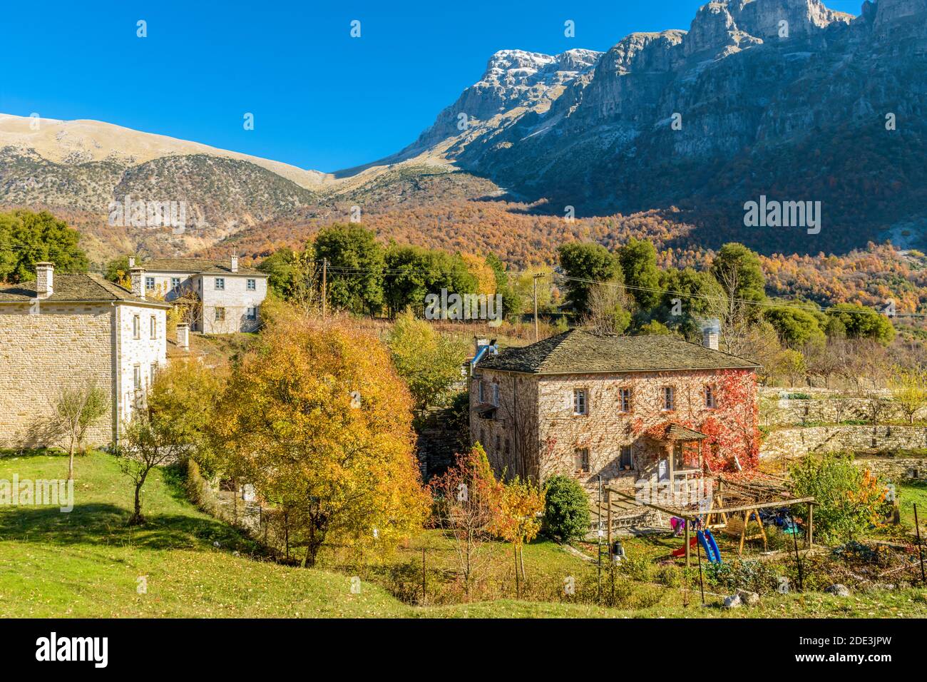 Architettura tradizionale con edifici in pietra e montagna astraka come sfondo Durante la stagione autunnale nel villaggio di Papigo a zagori Grecia Foto Stock