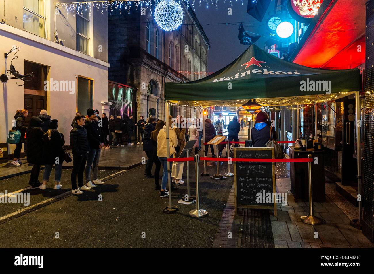 Cork, Irlanda. 28 Nov 2020. Il centro di Cork era molto affollato questa sera con le famiglie che vedeva le luci di Natale e altri che compravano bevande da asporto. Il bar Arthur Maynes su Pembroke Street aveva una grande coda di persone in attesa di acquistare alcolici. Credit: AG News/Alamy Live News Foto Stock