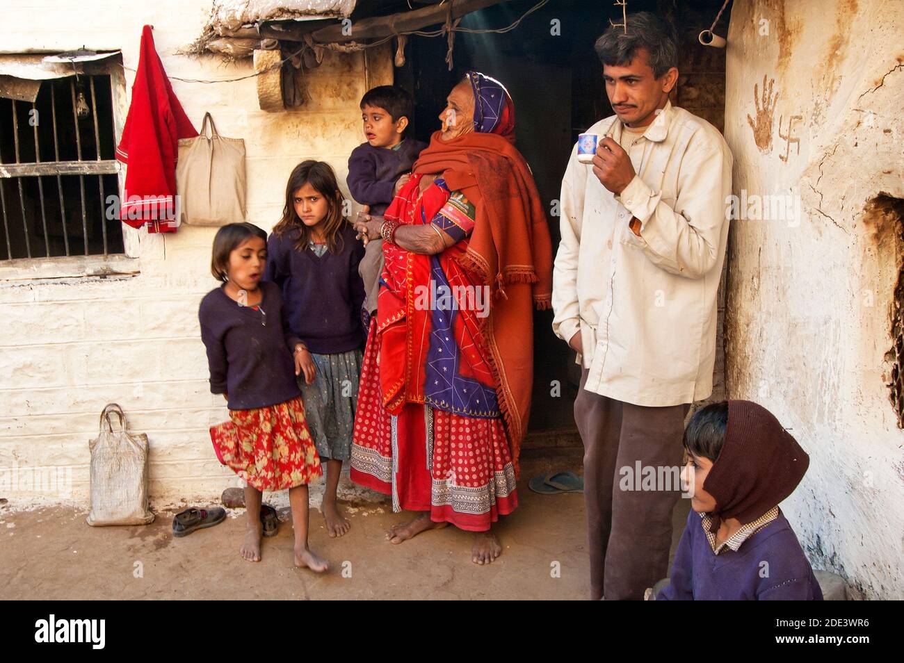 Family in their home entrance - Village in Rajasthan, India Foto Stock