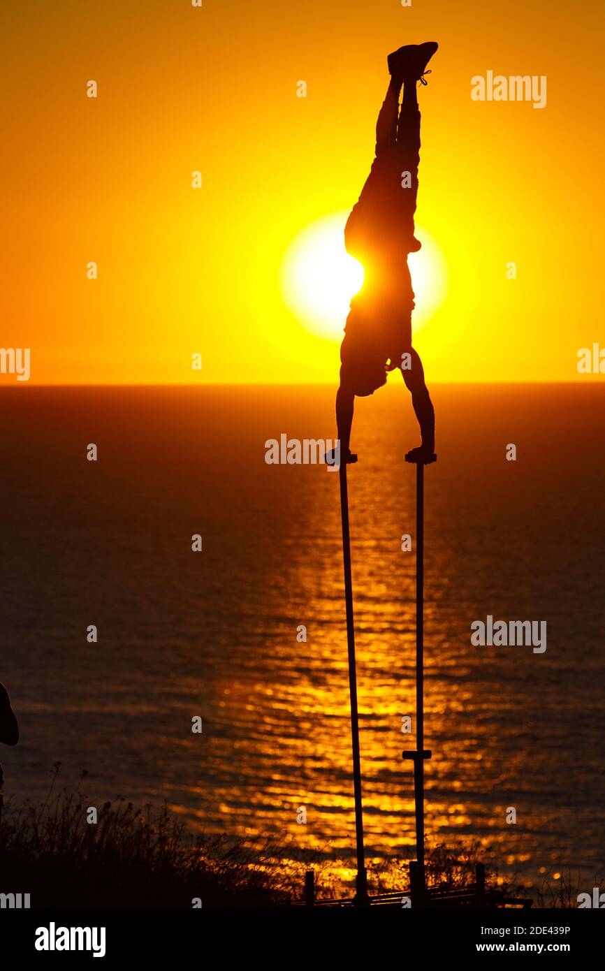 La JOLLA, CALIFORNIA. 27 novembre 2020. Un ginnasta outdddor fa un handstand su due pali con il sole che si tramonta dietro di lui a Torrey Pines Gliderport A. Foto Stock