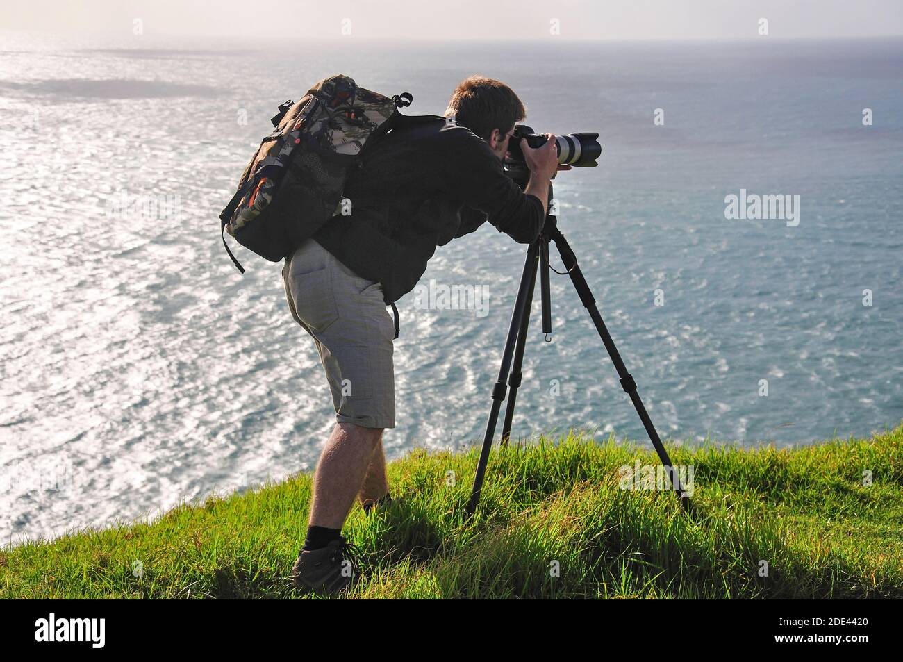 Fotografo con la fotocamera sul cavalletto, Cape Reinga, regione di Northland, Isola del nord, Nuova Zelanda Foto Stock