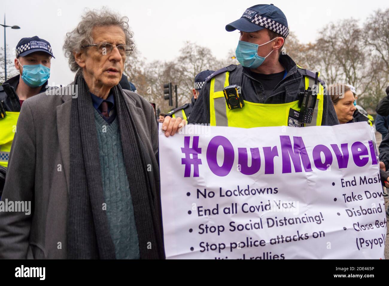 Piers Corbyn guida una protesta anti-blocco marcia a Hyde Park, Londra, Regno Unito, portando un nostro movimento banner, con poliziotto in maschera Foto Stock