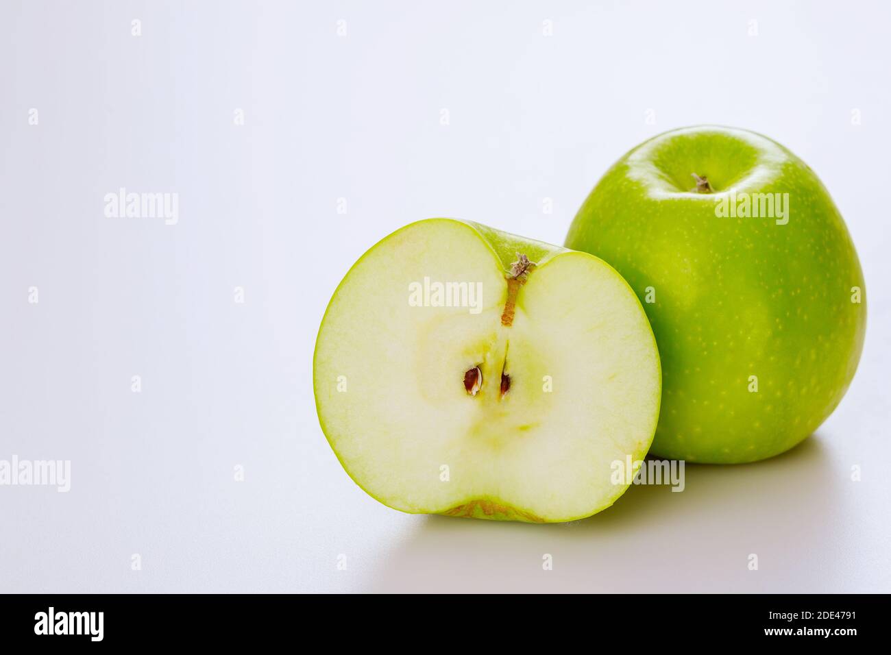 Mela tagliata verde e isolata su sfondo bianco. Produca il prodotto. Foto Stock