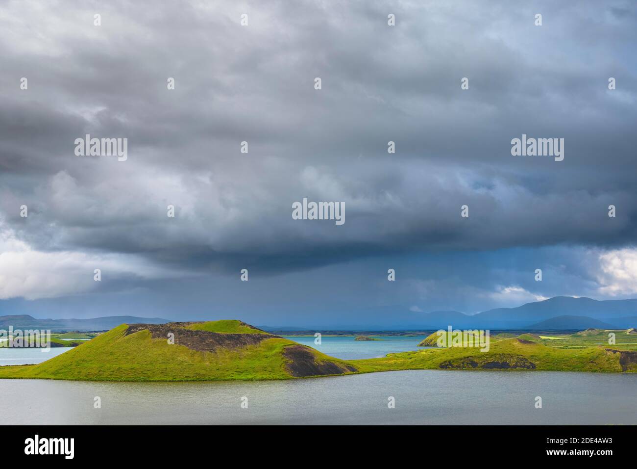 Pseudo-cratere verde, cratere vulcanico, con spettacolari nuvole al Lago Myvatn, Skutustaoir, Norourland eystra, Islanda Foto Stock