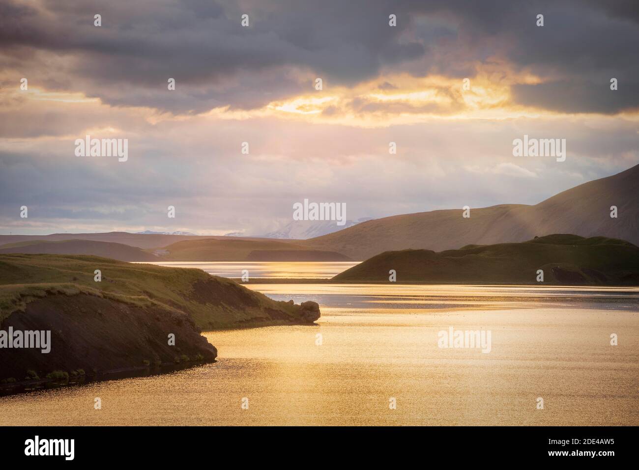Il sole si rompe attraverso le nuvole sul lago con le colline, Myvattn, Skutustaoir, Norourland eystra, Islanda Foto Stock