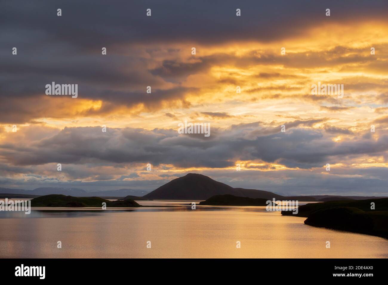 Le colline con nuvole nella luce della sera si riflettono nel lago Myvattn, Skutustaoir, Norourland eystra, Islanda Foto Stock