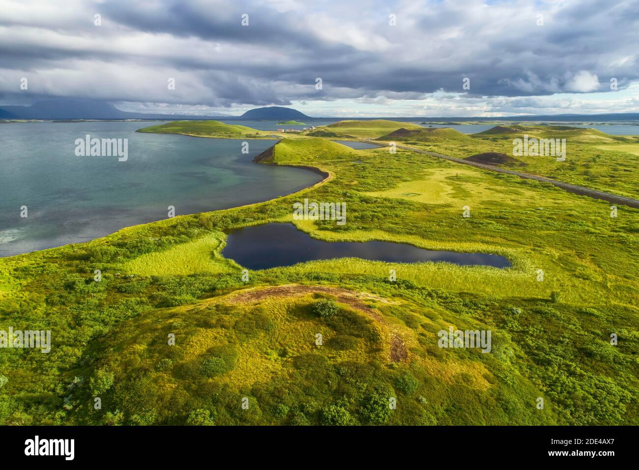 Vista aerea del verde cratere vulcanico, pseudo-cratere con spettacolari nuvole al Lago Myvatn, Skutustaoir, Norourland eystra, Islanda Foto Stock