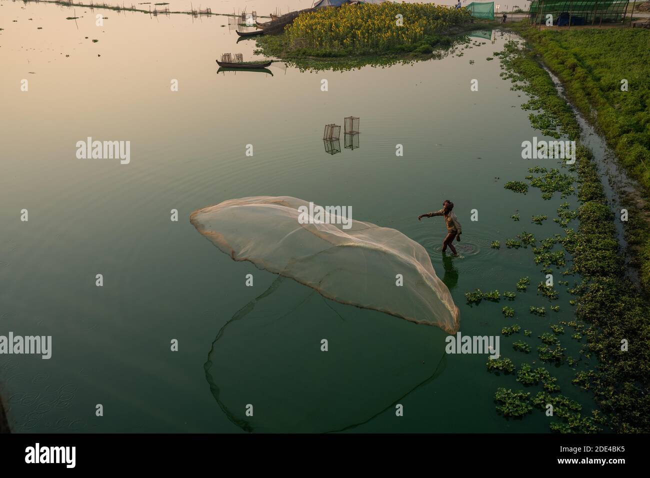 I pescatori sul lago Taung Tha Man gettano fuori una rete di pesca per l'alba, la riflessione in acqua, il lago Thaung Tha Man, Mandalay, Myanmar Foto Stock