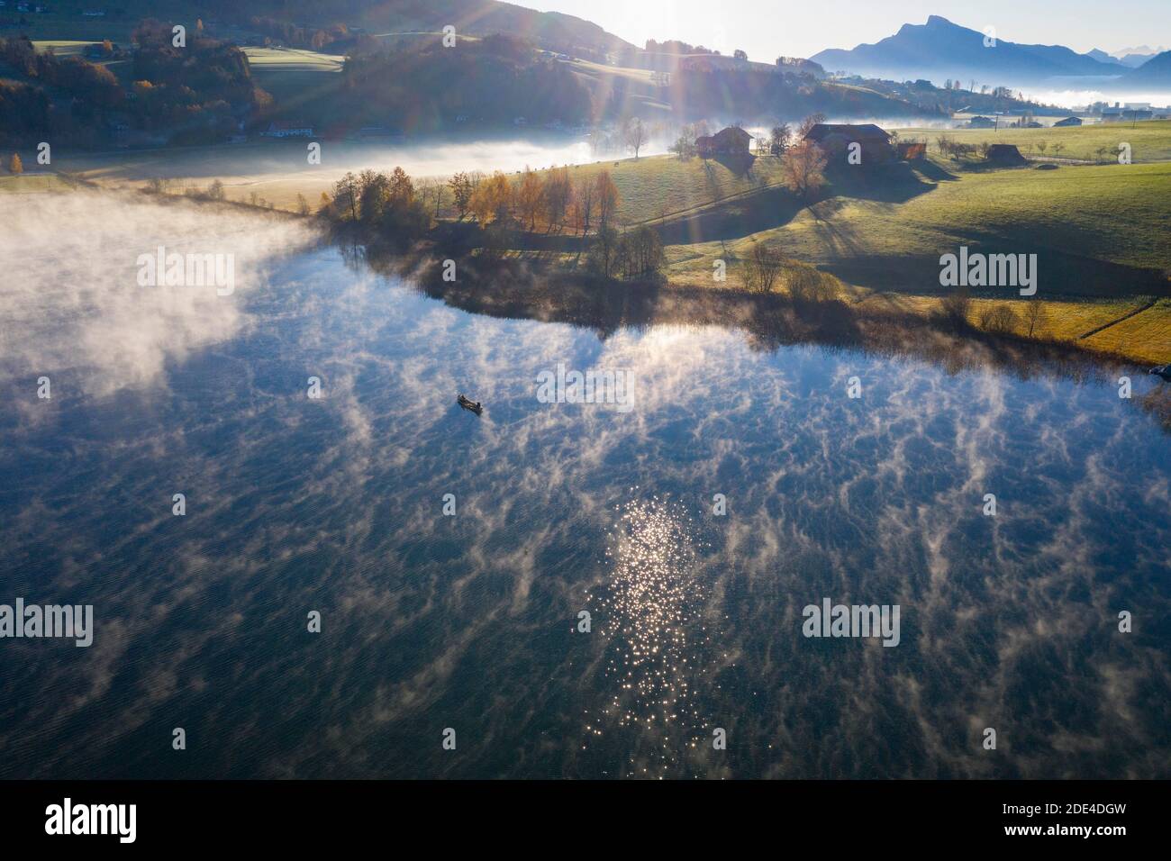 Cialde di nebbia al lago Irrsee con barca da pesca e vista su Mondseeland, nebbia a terra, dall'alto, foto del drone, foto aerea, Salzkammergut, Upper Foto Stock