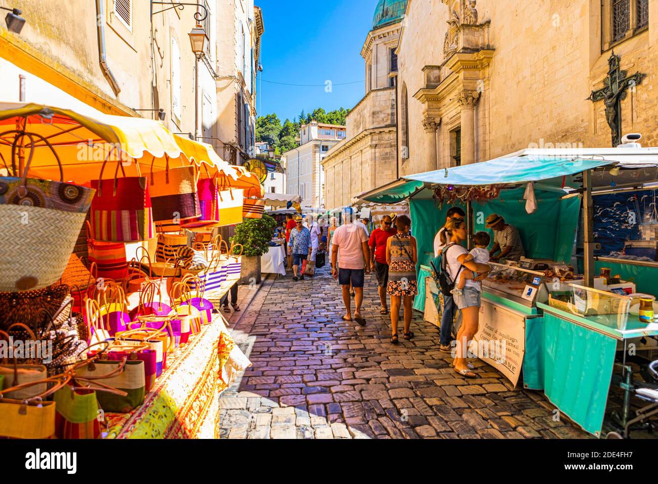 I turisti passeggiano tra le bancarelle del mercato settimanale di Apt, Luberon, Provenza, Francia Foto Stock