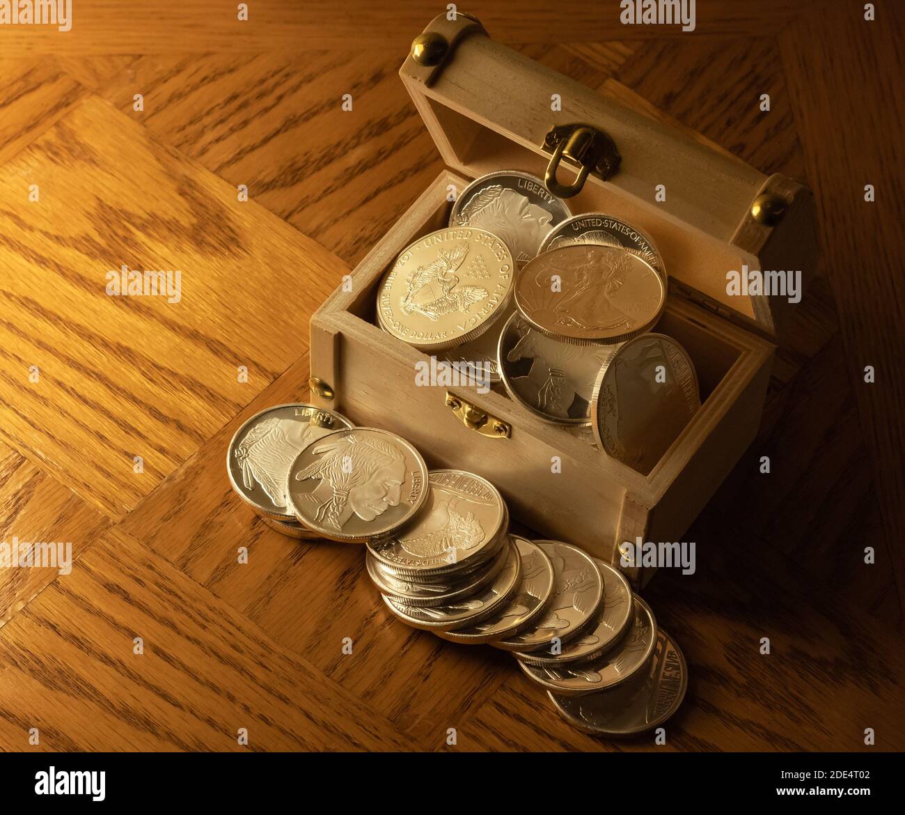 Monete d'argento in una scatola di tesori di legno su sfondo di legno marrone. Messa a fuoco selettiva, tesoro di foto concettuali. Foto Stock