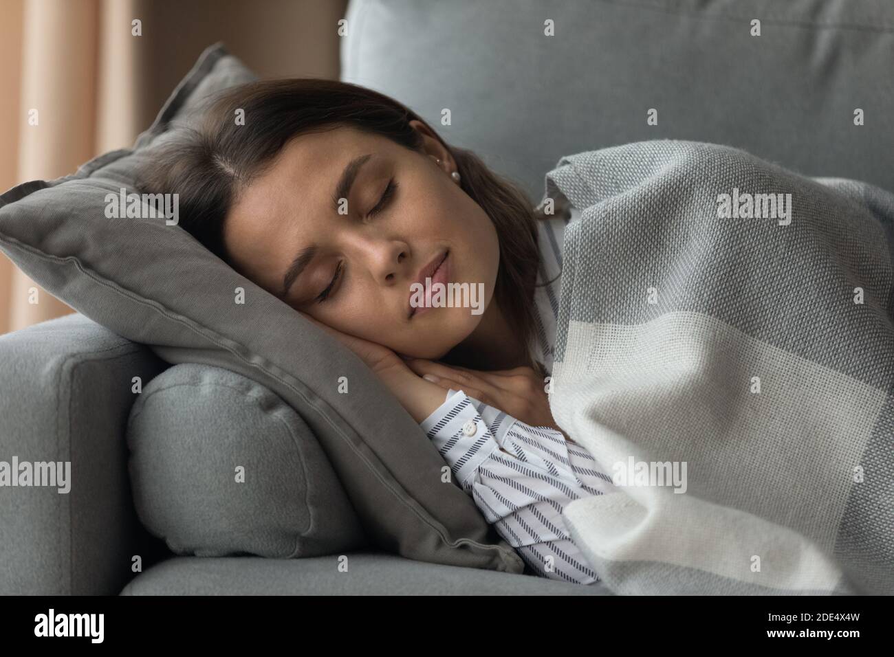 Stanca giovane donna rilassarsi sul divano dormire Foto Stock