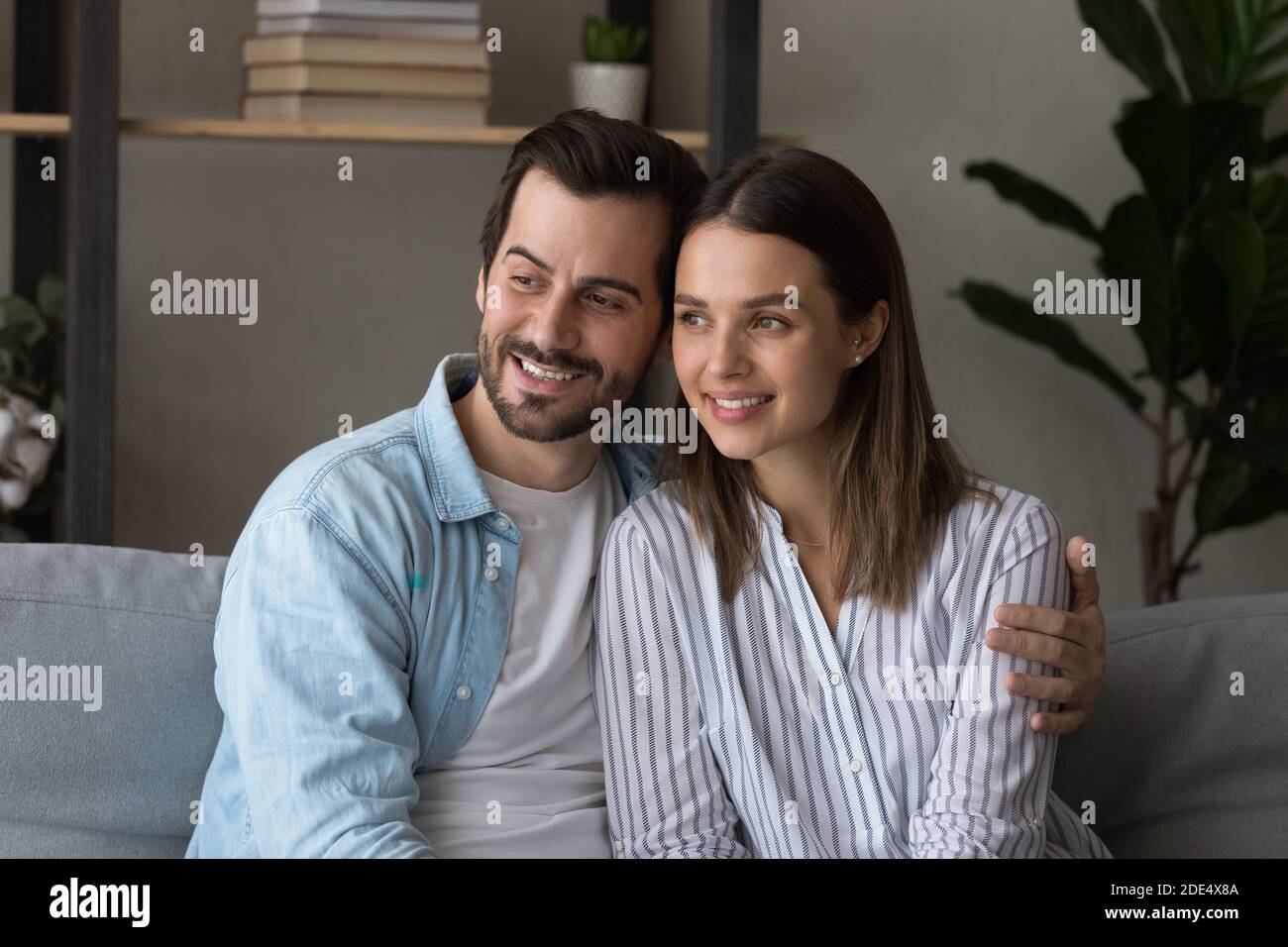 Una coppia felice coccola a casa sognando insieme Foto Stock