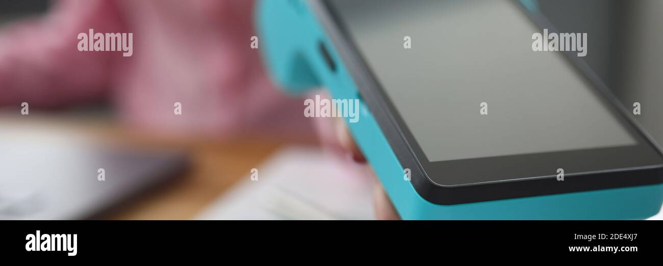 Ragazza tiene fuori terminale portatile per la carta di pagamento Foto Stock