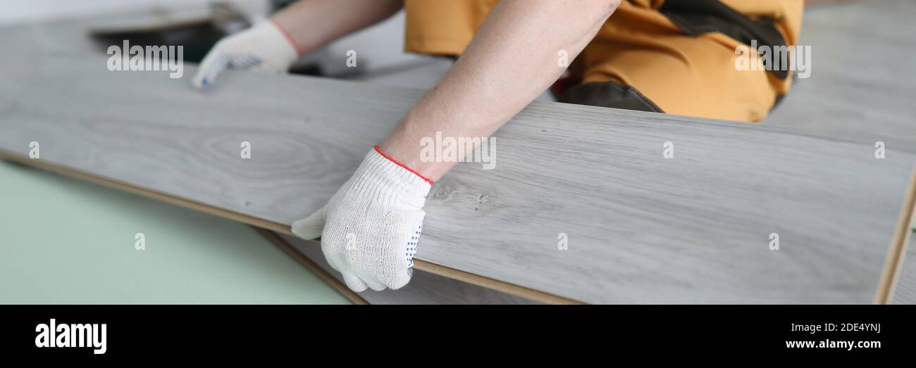 Repairman sostituisce l'appartamento con pannelli laminati Foto Stock