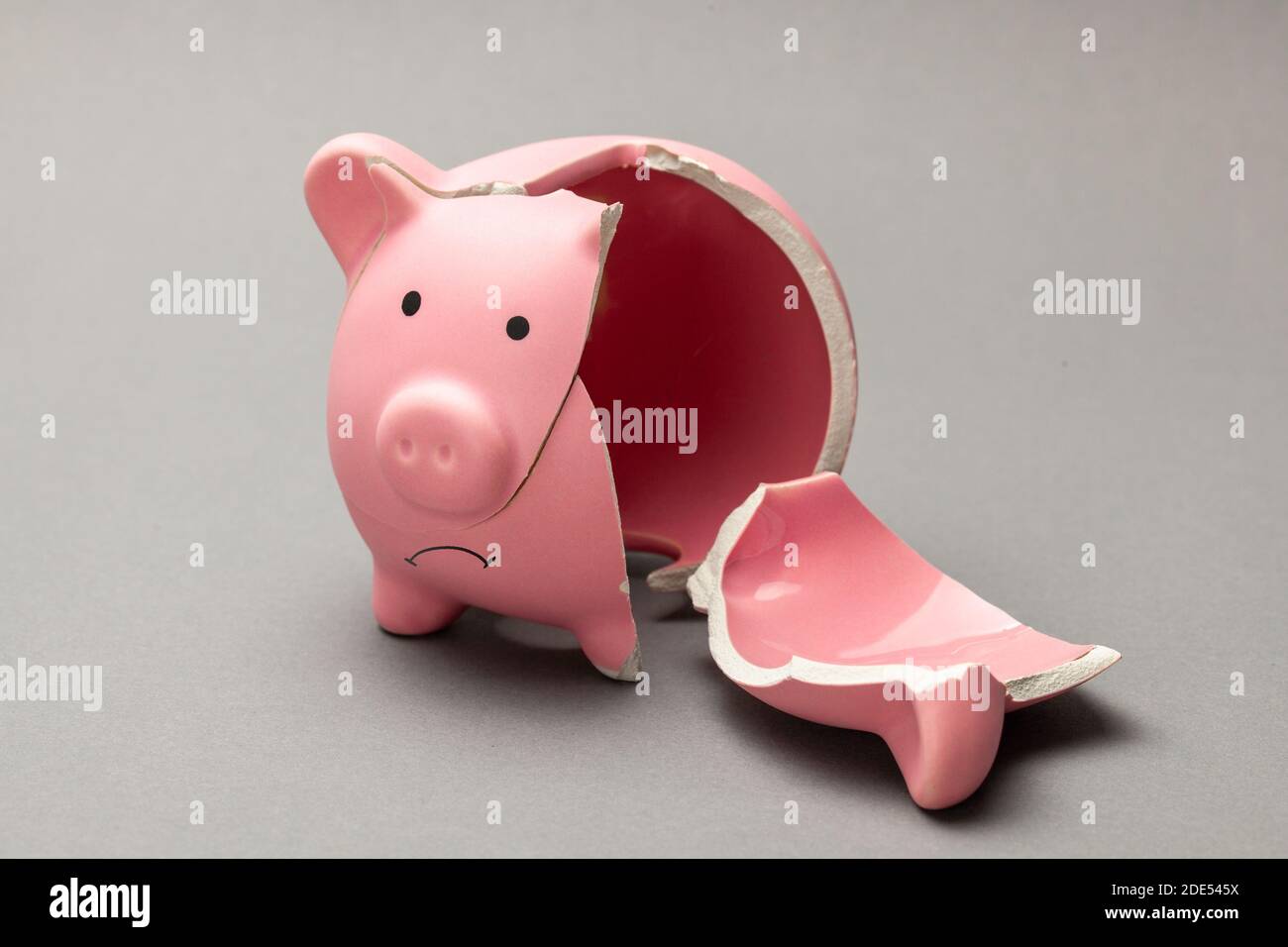 Banco di piggy rotto su sfondo grigio. Foto Stock