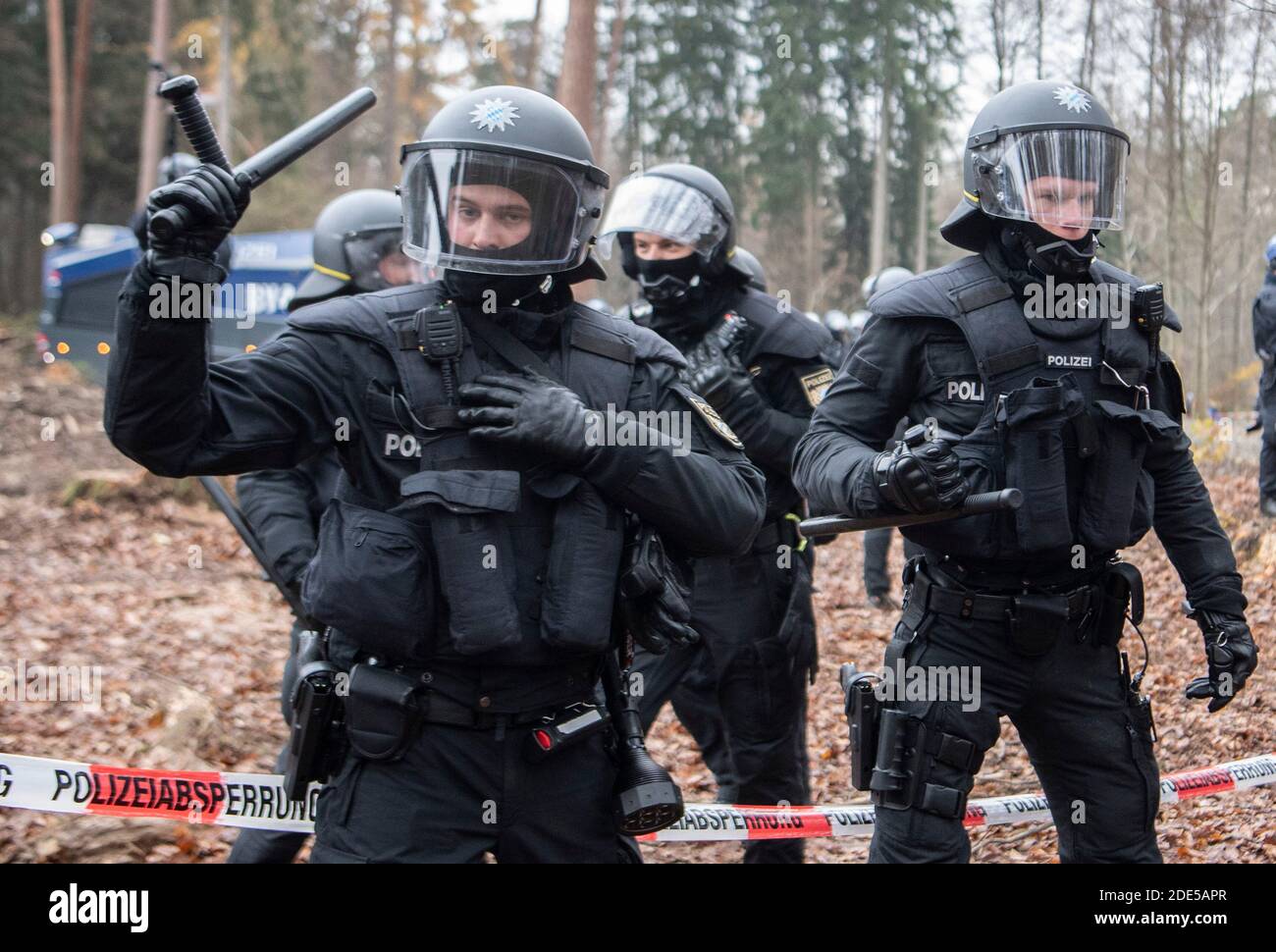 Dannenrod, Germania. 29 Nov 2020. Con i loro truncheon sollevati, la polizia minaccia gli attivisti che si avvicinano al cordone lungo la strada di disboscamento. I protettori ambientali e climatici protestano da mesi nella foresta di Dannenröder contro la controversa e continuata costruzione dell'Autobahn 49. Credit: Boris Roessler/dpa/Alamy Live News Foto Stock