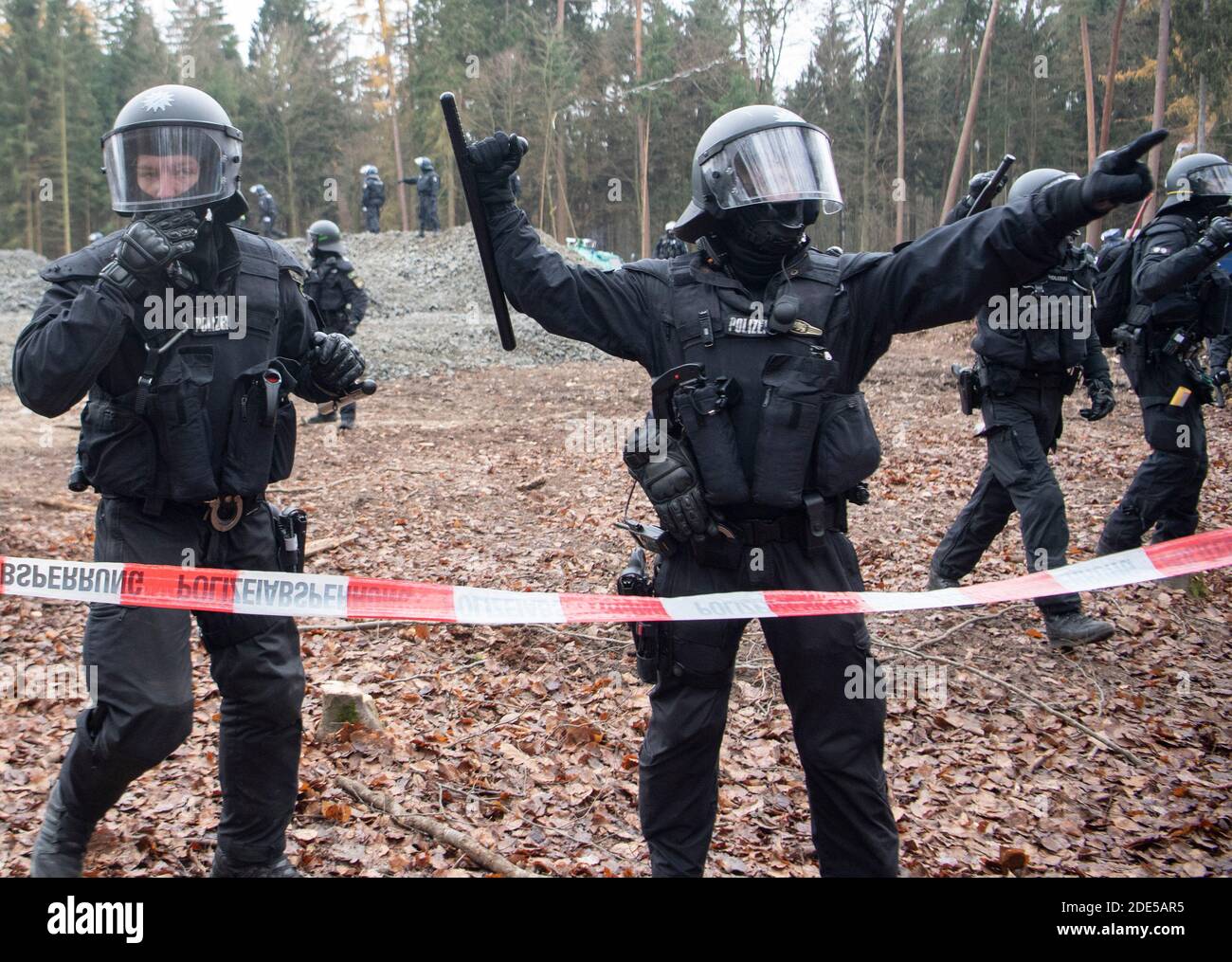 Dannenrod, Germania. 29 Nov 2020. Con i loro truncheon sollevati, la polizia minaccia gli attivisti che si avvicinano al cordone lungo la strada di disboscamento. I protettori ambientali e climatici protestano da mesi nella foresta di Dannenröder contro la controversa e continuata costruzione dell'Autobahn 49. Credit: Boris Roessler/dpa/Alamy Live News Foto Stock