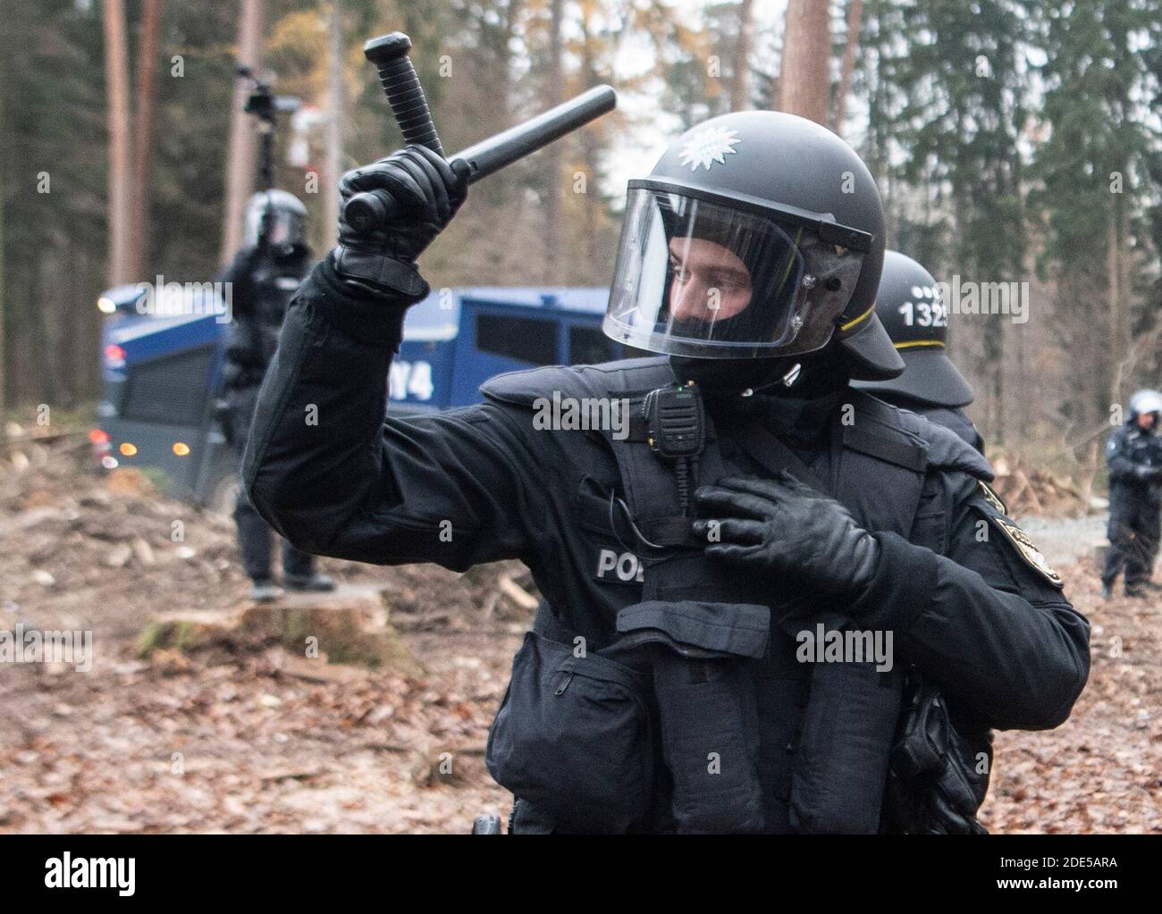 Dannenrod, Germania. 29 Nov 2020. Con i loro truncheon sollevati, la polizia minaccia gli attivisti che si avvicinano al cordone lungo la strada di disboscamento. I protettori ambientali e climatici protestano da mesi nella foresta di Dannenröder contro la controversa e continuata costruzione dell'Autobahn 49. Credit: Boris Roessler/dpa/Alamy Live News Foto Stock