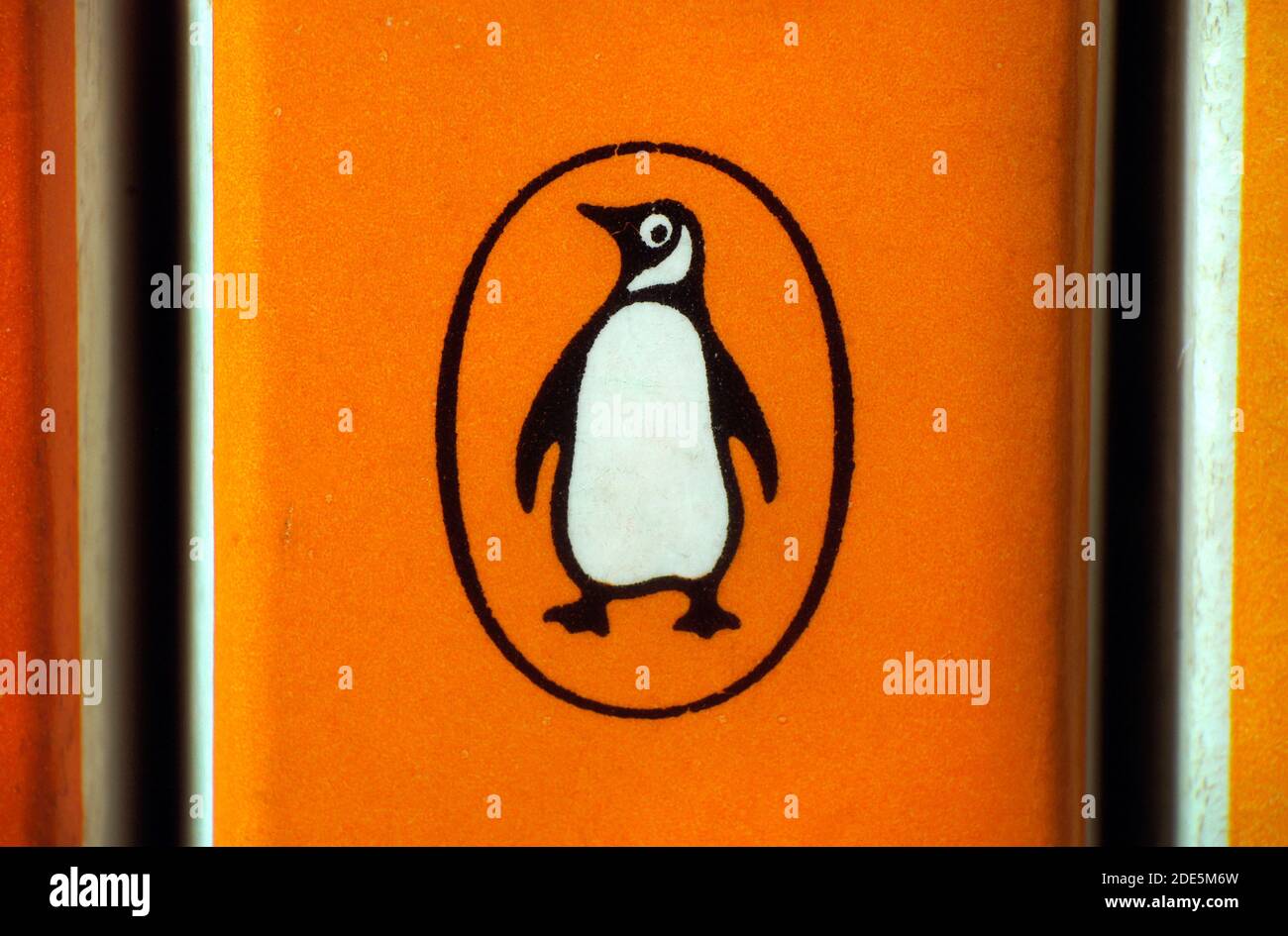 Primo piano dell'iconico logo Penguin sul dorso del libro cartaceo di 1970s pinguini arancione. Penguin è ora parte del conglomerato editoriale della Casa casuale del pinguino. Foto Stock