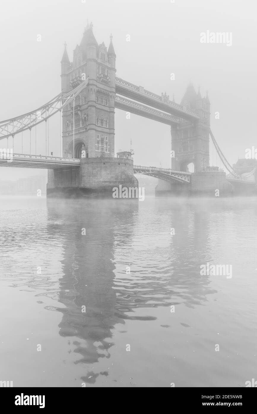 Black and White Tower Bridge e River Thames in atmosfera nebbia e nebbiosa, vicino all'acqua in condizioni atmosferiche umide nel centro di Londra sul Coronavirus Covid-19 Lockdown Day One, England, UK Foto Stock