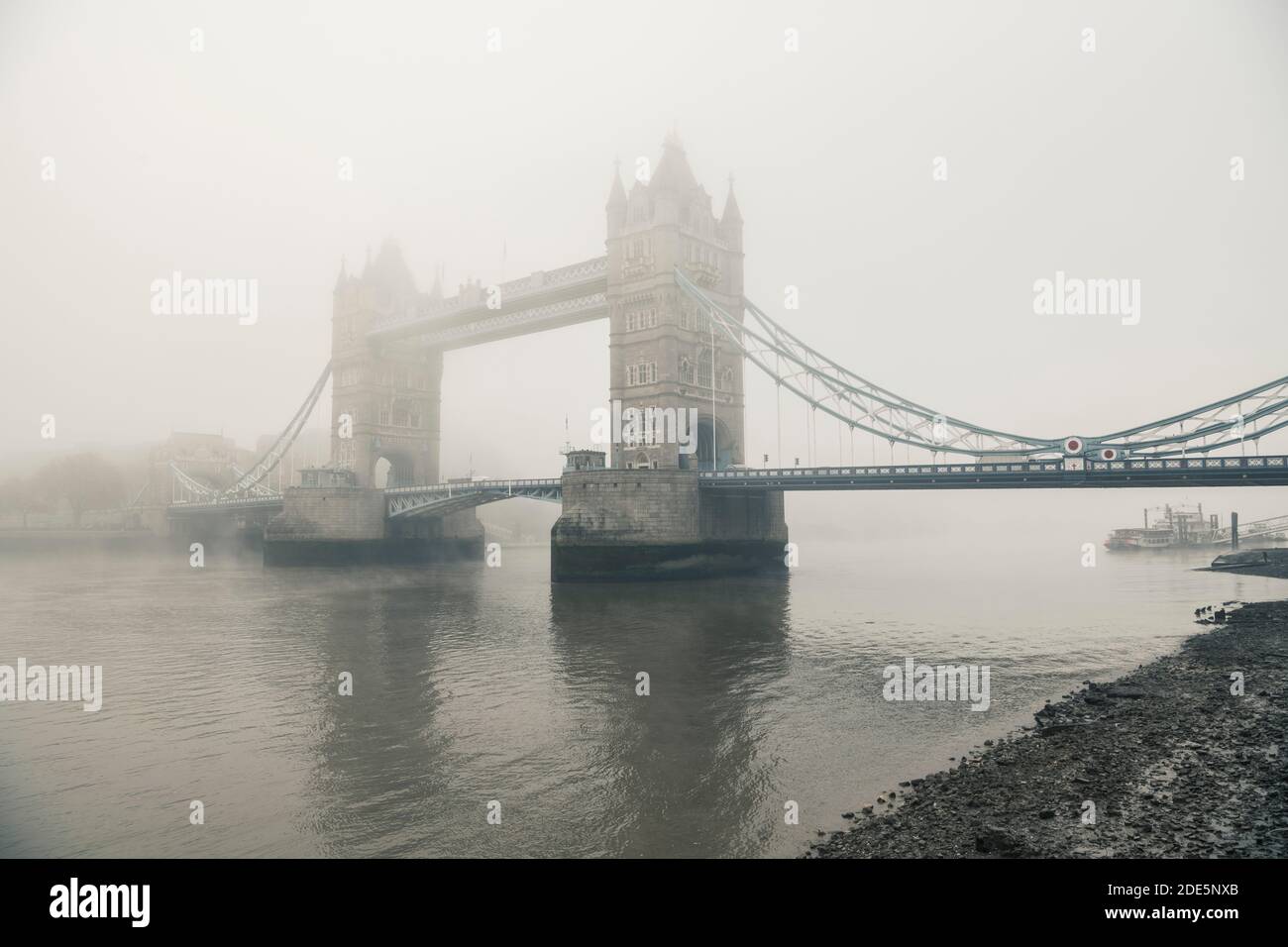 Ponte della Torre di Seppia e Tamigi con bassa marea in atmosfera nebbiosa e fosca, condizioni meteorologiche umide nel centro di Londra sul Coronavirus Covid-19 Lockdown giorno uno, Inghilterra, Regno Unito Foto Stock