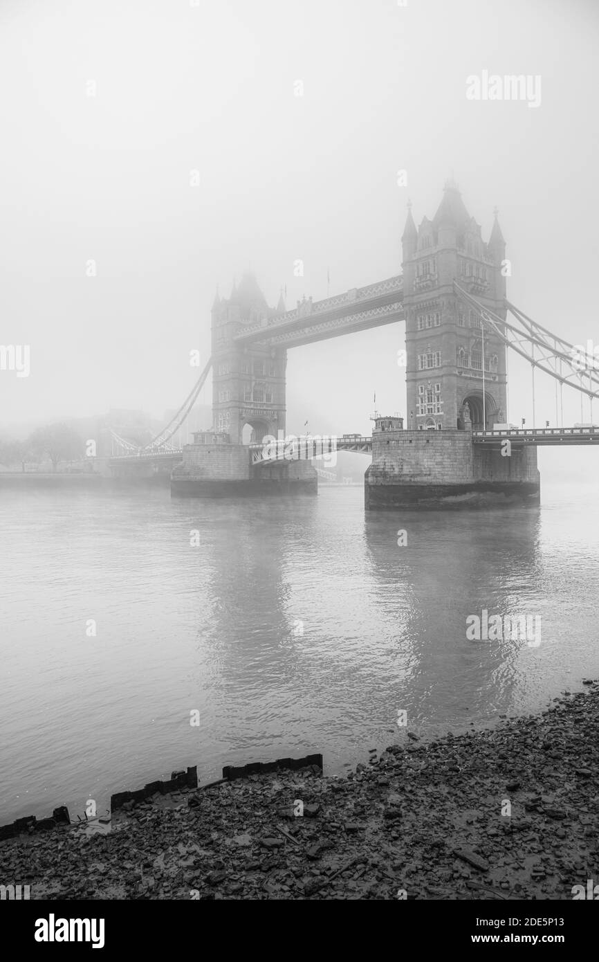 Black and White Tower Bridge e River Thames a bassa marea in atmosfera nebbia e nebbiosa, condizioni meteorologiche umide nel centro di Londra sul Coronavirus Covid-19 Lockdown giorno uno, Inghilterra, Regno Unito Foto Stock