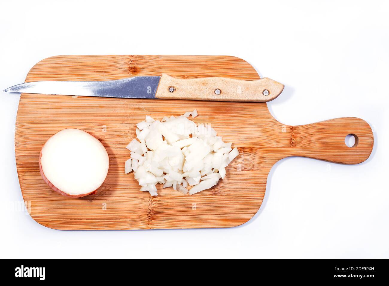 Tritato e mezza cipolla su un tagliere di legno isolato su sfondo bianco Foto Stock