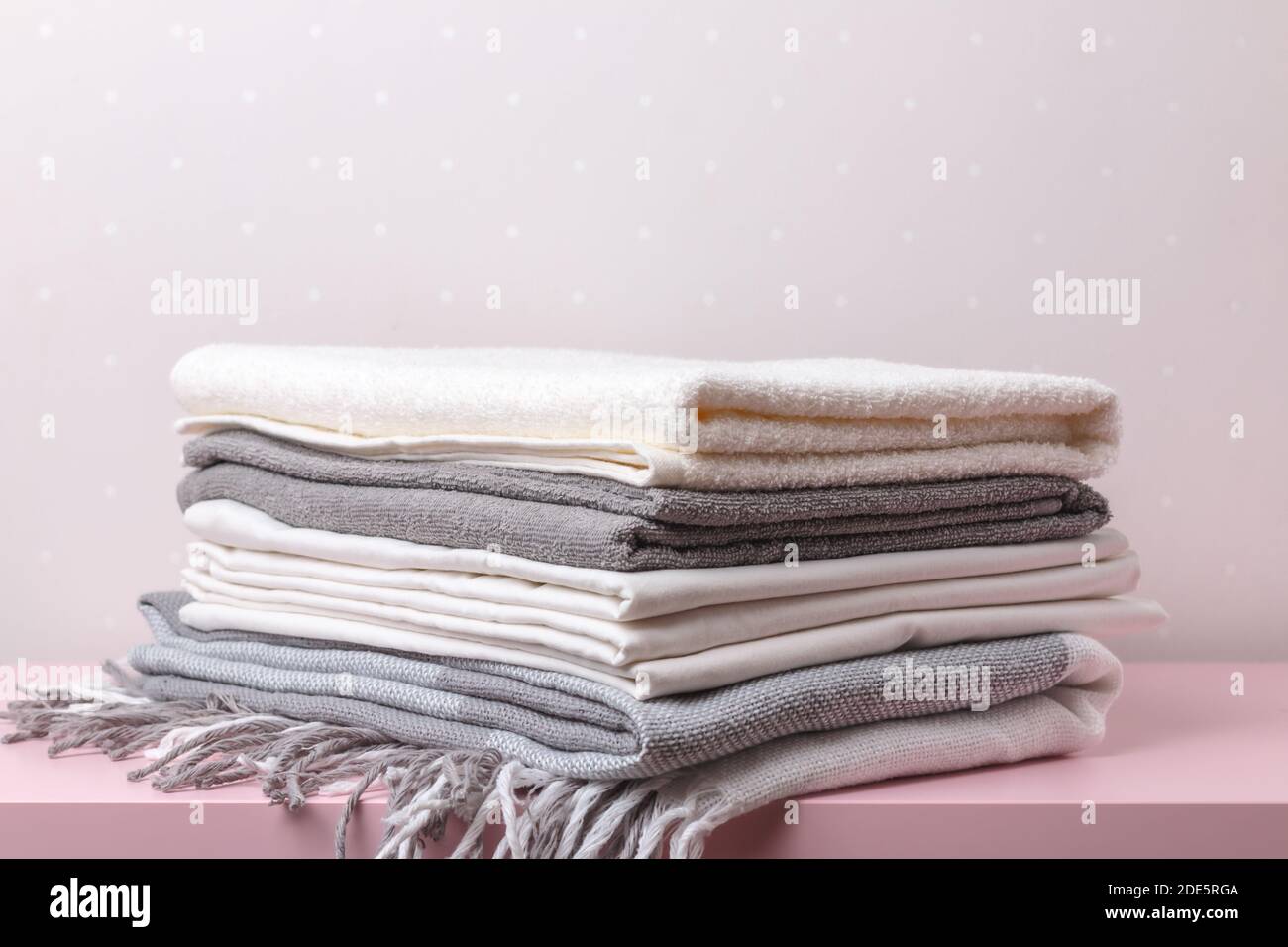 Una pila di coperte, fogli e asciugamani arrotolati sul tavolo. Foto Stock