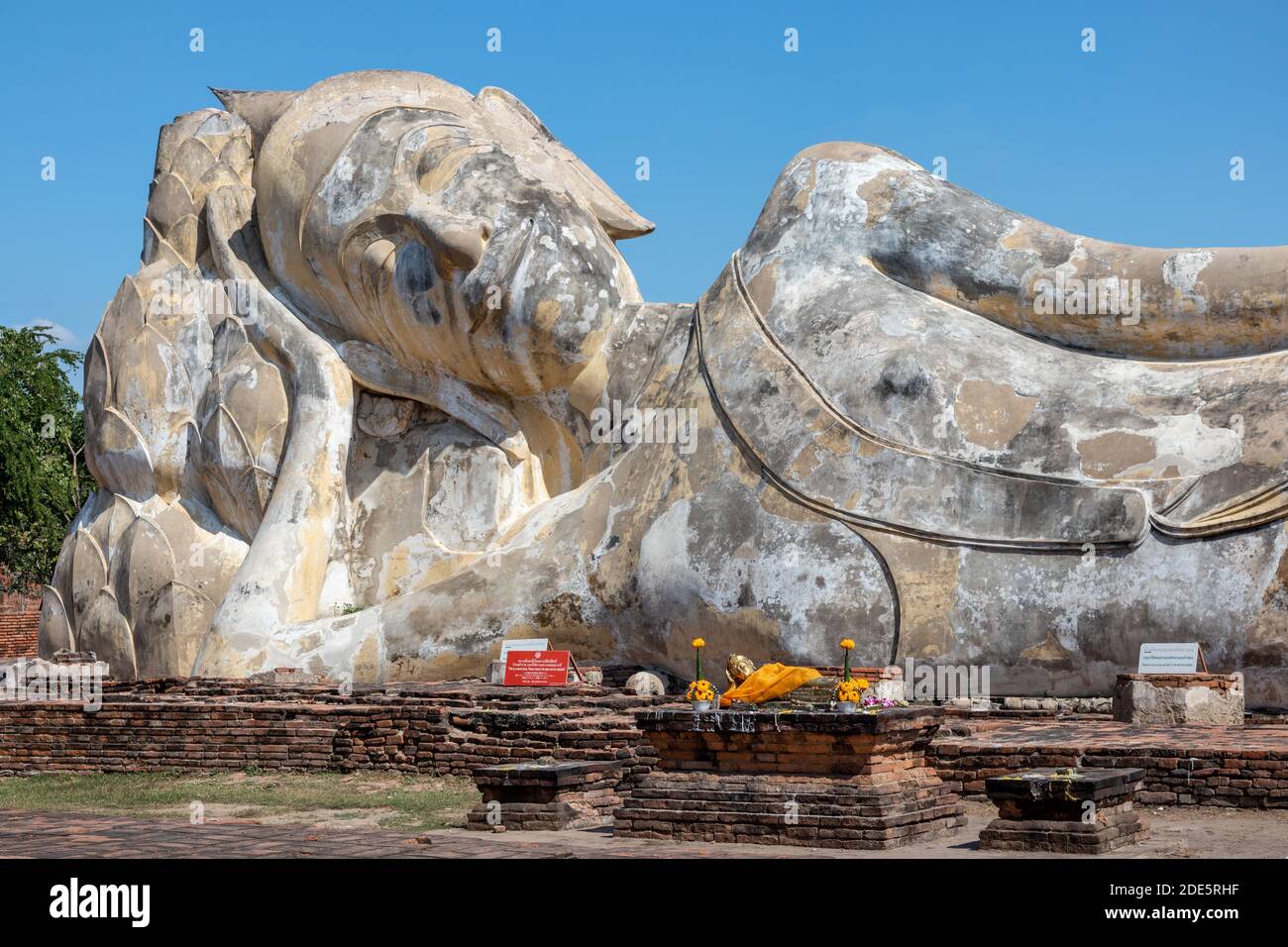 Thailandia; Gen 2020: Statua gigante di Buddha in posizione reclinata posto all'aperto, grande statua in pietra. Wat Lokayasutharam - Tempio del reclinazione Foto Stock