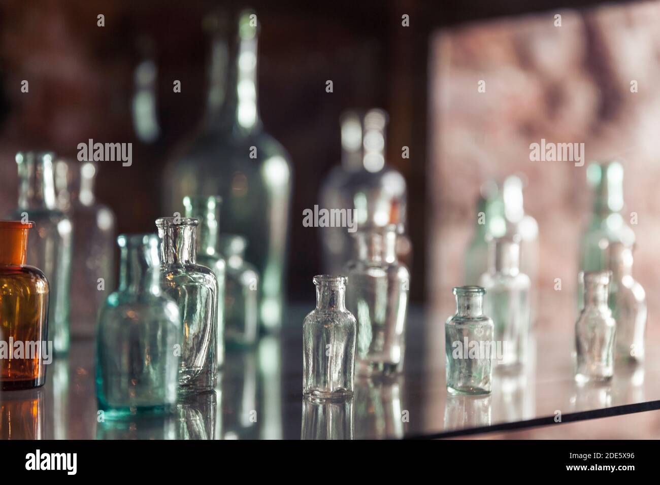 I flaconcini di vetro vintage vuoti si trovano su un ripiano in una farmacia Foto Stock