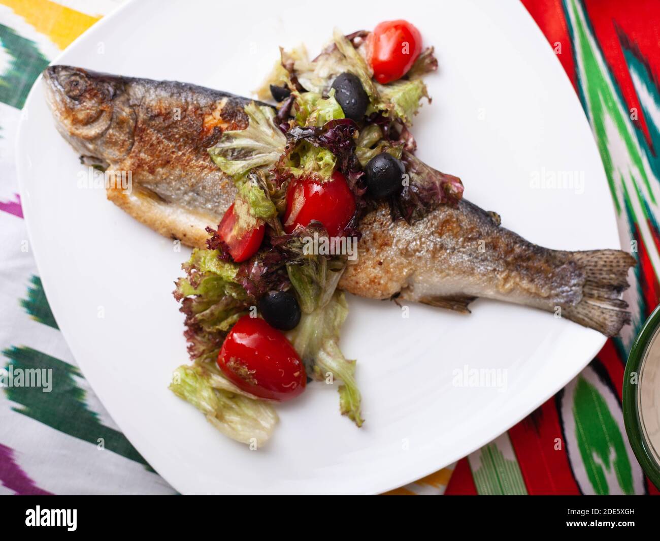 Pesce fritto con un cuscino di verdure stufate. Stile Asiatico Foto Stock