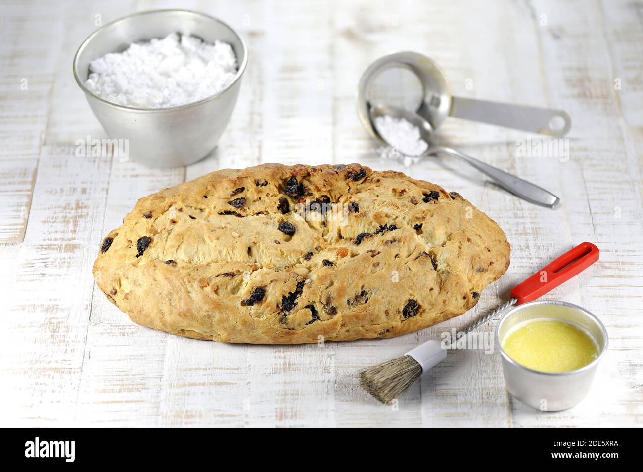 Stollen di Natale sassone tradizionale appena sfornato con alcuni ingredienti da forno da rifinire con zucchero in polvere Foto Stock