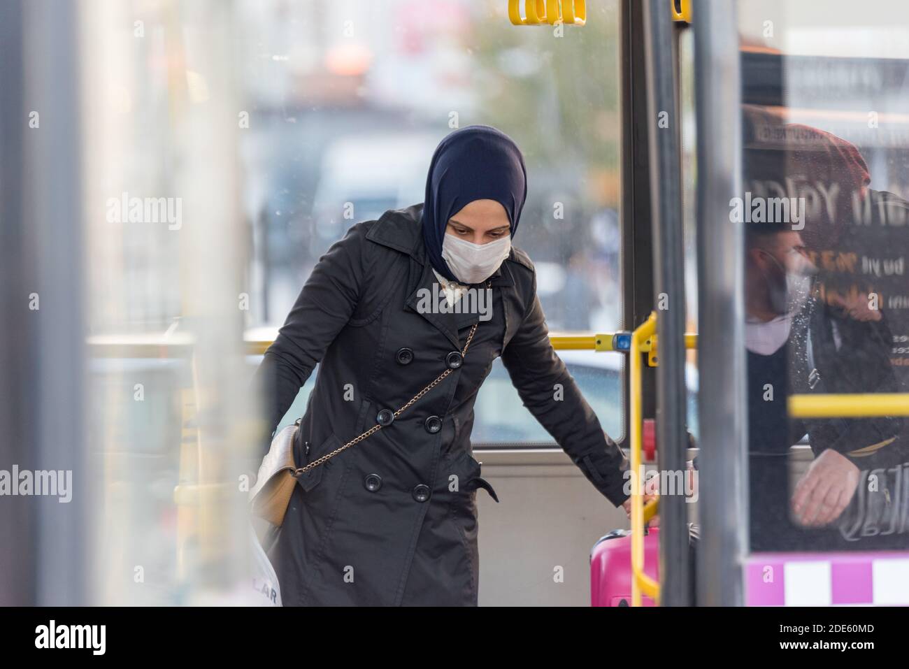 Persone turche non identificate che indossano maschere facciali di protezione si muovono per ottenere Fuori agli autobus durante il coronavirus COVID-19 Epidemic.Istanbul,Turchia.16 novembre 20 Foto Stock